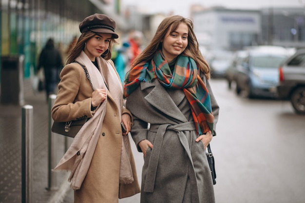 Dwa dziewczyny na zewnątrz centrum handlowego w jesień dniu