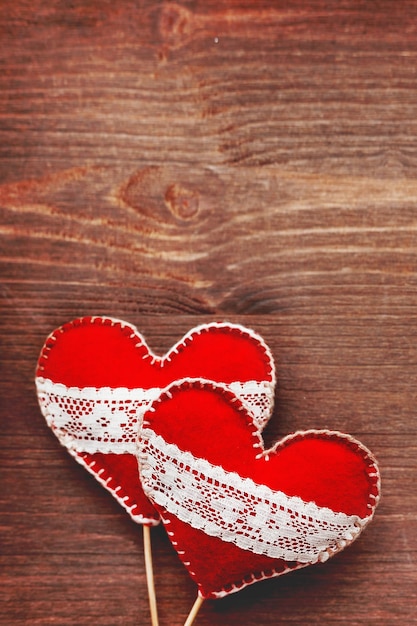 Dwa filcowe serca z sznurówkami symbolem miłości na drewnianym tle kopiowanie kartki na Dzień Walentynek