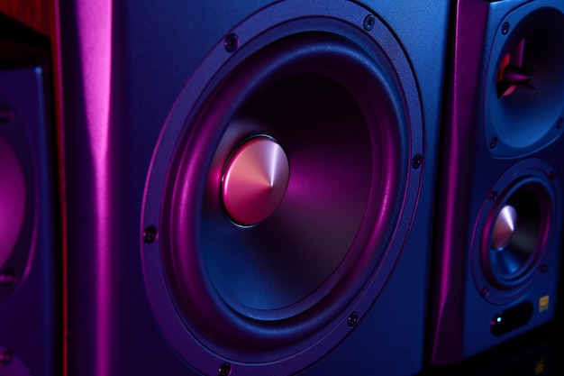 Dwa głośniki i subwoofer na ciemnym tle z neonami