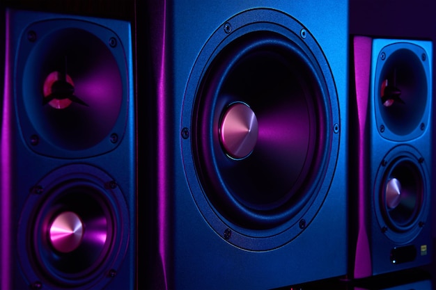 Dwa głośniki i subwoofer na ciemnym tle z neonami