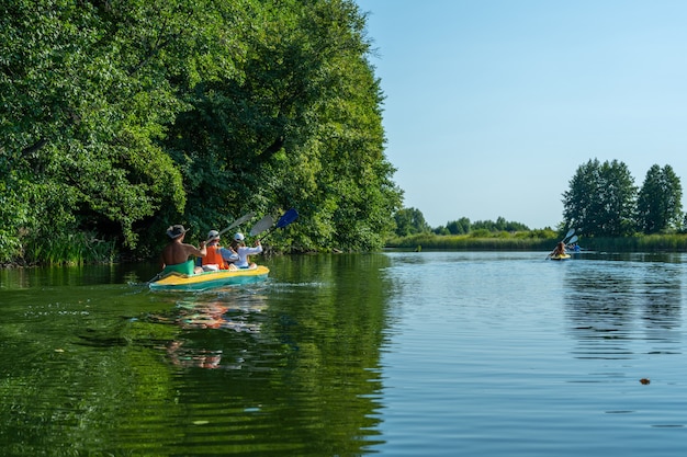 Dwa kajaki z grupą kilku osób wiosłujących. Rafting na szybkiej rzece. Przygodowy styl życia. Koncepcja wędrówki. Aktywne wakacje weekendowe dzikiej przyrody na świeżym powietrzu. Kajakarstwo.