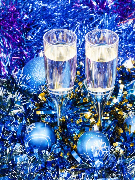 Dwa kieliszki do szampana w niebieskich dekoracjach świątecznych