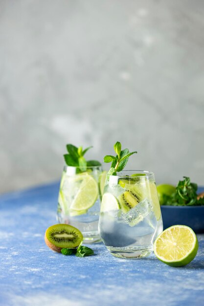 Dwa koktajle detox water lub martini tonic z lodem z limonki kiwi i miętą Nowy rodzaj mojito z limonką kiwi i miętą oraz oczywiście lodem