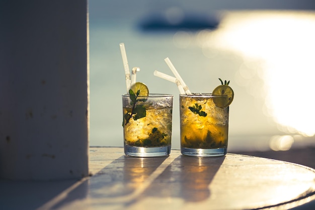 Dwa koktajle mojito na tle zachodzącego słońca na plaży, Egipt