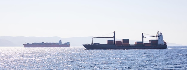 Dwa kontenerowce do transportu międzynarodowego pływają pełne ładunku Baner tła nieba handlu morskiego