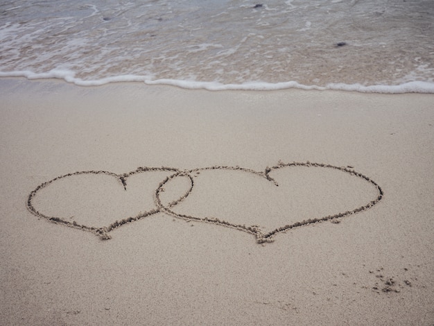 Dwa Kształty Serca Pisania Na Piaszczystej Plaży Z Falami Oceanu
