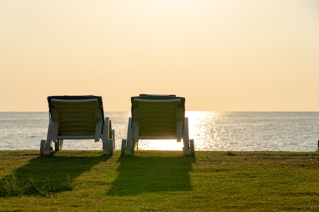 Dwa leżaki na piaszczystej plaży w pobliżu morza w Phuket, Tajlandia.