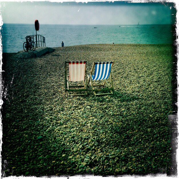 Zdjęcie dwa leżaki na plaży.