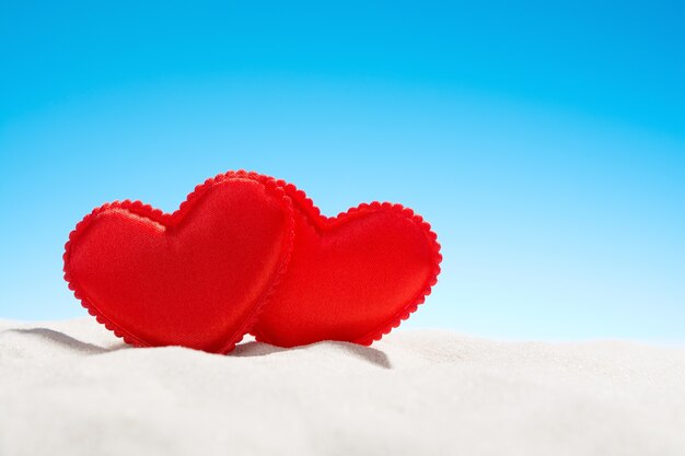 Dwa małe czerwone serca na plaży