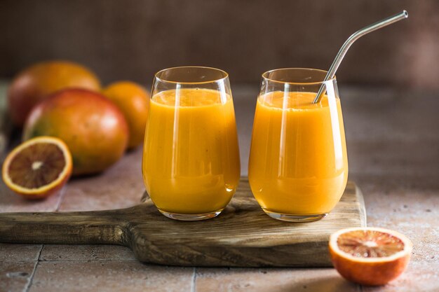 Dwa mango lassi lub mleko kesar w szklankach Indyjski zdrowy ajurwedyjski zimny napój z mango Świeżość lassi z jogurtu woda przyprawy owoce i lód