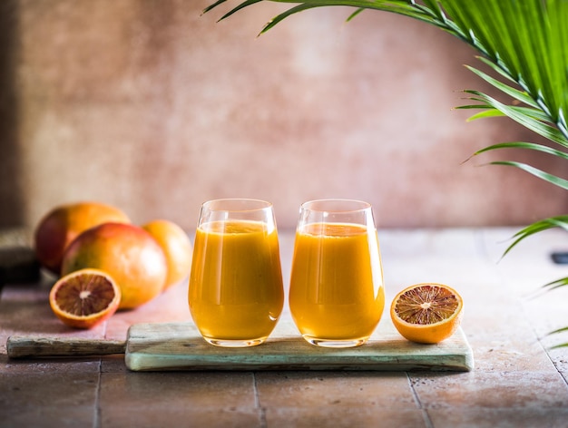 Dwa mango lassi lub mleko kesar w szklankach Indyjski zdrowy ajurwedyjski zimny napój z mango Świeżość lassi z jogurtu woda przyprawy owoce i lód