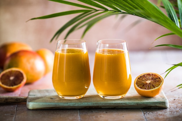 Dwa mango lassi lub mleko kesar w szklankach Indyjski zdrowy ajurwedyjski zimny napój z mango Świeżość lassi z jogurtu woda przyprawy owoce i lód