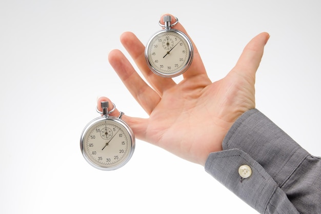 Dwa mechaniczne stopery wiszą na palcach męskiej dłoni Precyzja części czasu Pomiar odstępu prędkości