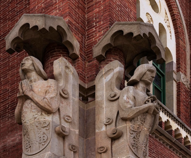 Dwa posągi na budynku z napisem anioł na froncie.