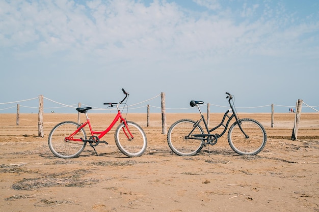 Zdjęcie dwa stare rowery na plaży przed morzem