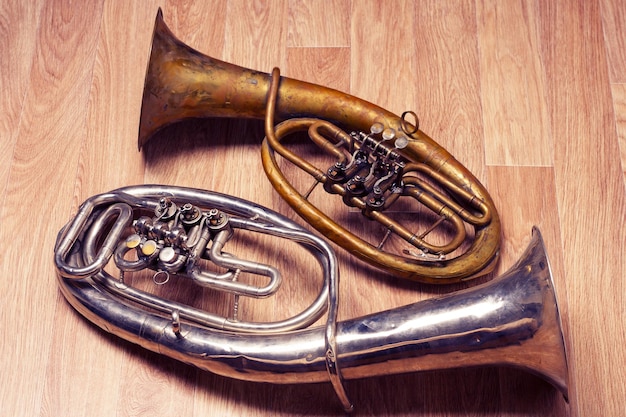 Zdjęcie dwa stare zardzewiałe saksofony altowe na drewnianym tle