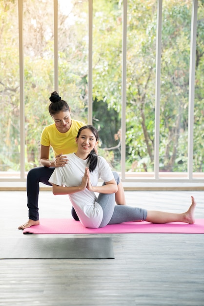 Zdjęcie dwa szczęśliwej azjatykciej kobiety w joga pozach w joga studiu z naturalnego światła położenia sceną, ćwiczenia pojęcie / joga praktyka / kopii przestrzeń / joga studio