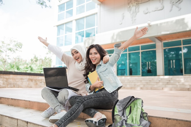 Dwa szczęśliwy student collegu używa laptop