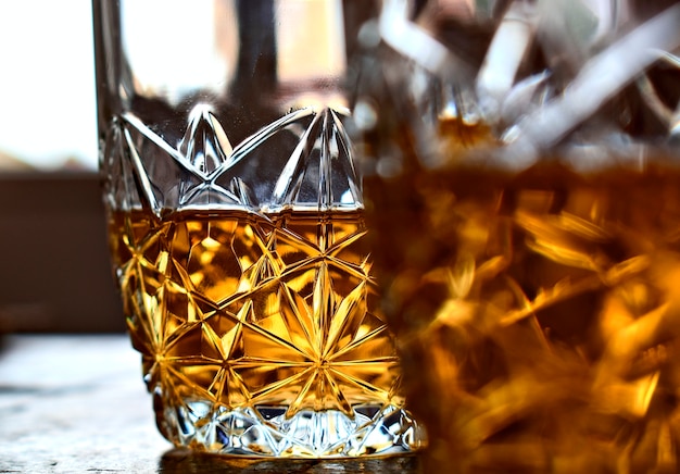 Dwa szkła whisky na starym kamienia stole i tle jaskrawy okno.