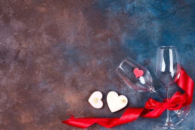 Zdjęcie dwa szkła wino, ciastek serca na kamiennym tle. walentynki