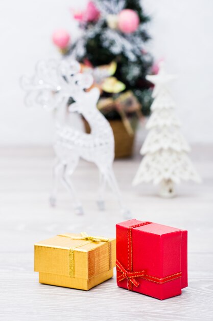 Dwa zapakowane prezenty w pudełkach i ozdoby świąteczne na szarym drewnianym stole