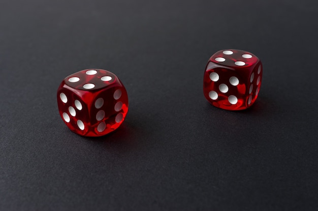 Zdjęcie dwie czerwone kostki do gry na czarnym stole