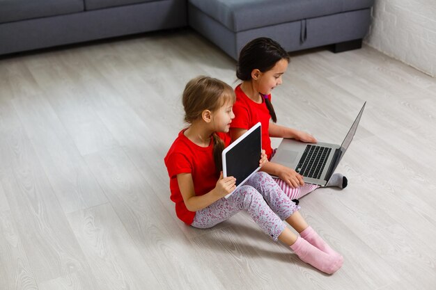 Dwie Dziewczynki Siedzące Przed Laptopem I śmiejące Się, Zbliżenie, Pozytywne Emocje, Rozrywka W Internecie Dla Dzieci