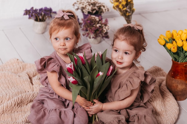 Dwie dziewczynki w pięknych sukienkach w pracowni w kwiaty