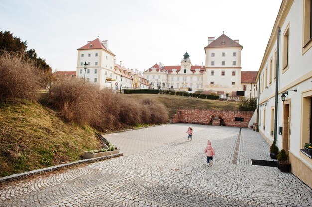 Dwie dziewczyny noszą różową kurtkę spacerując po mieście Valtice w Czechach