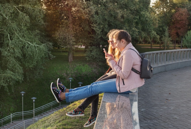 Dwie dziewczyny robią zdjęcie swoim stopom przez telefon