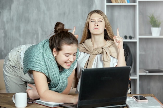 Dwie dziewczyny śmieją się i rozmawiają o najnowszych plotkach w Internecie