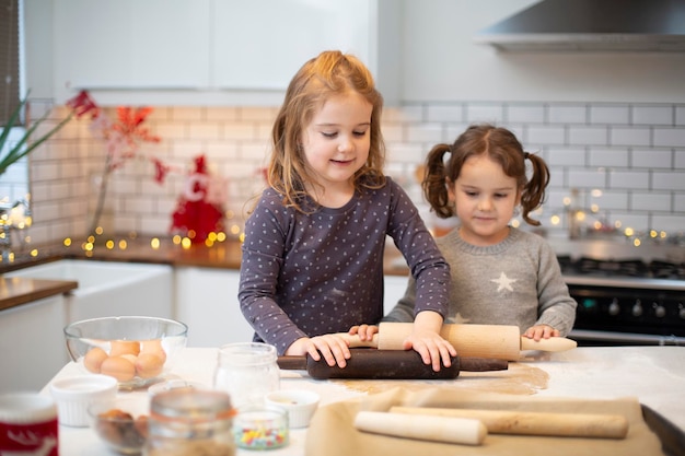 Dwie dziewczyny stoją w kuchni i pieką świąteczne ciasteczka