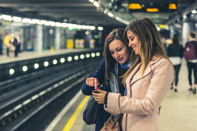 Dwie dziewczyny w londyńskim metrze czekają na pociąg.