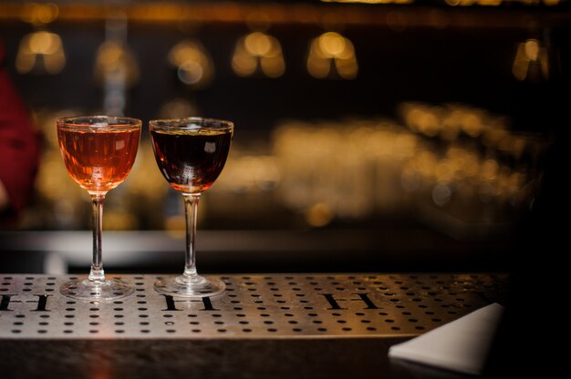 Zdjęcie dwie eleganckie szklanki do koktajli wypełnione napojami alkoholowymi
