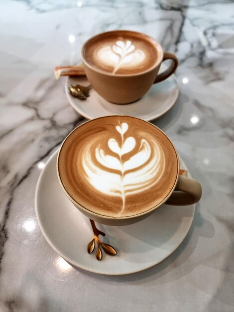 Zdjęcie dwie filiżanki gorącej kawy latte art prosty kawa tulipan na stole
