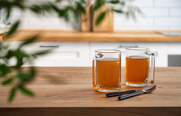 Dwie filiżanki herbaty i brunch liść z bliska na drewnianym blacie na tle białej kuchni wczesnym rankiem Koncepcja zdrowego śniadania