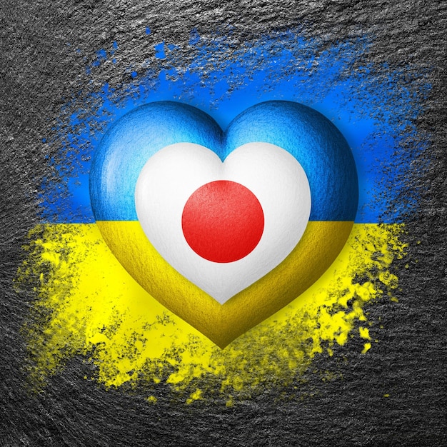 Dwie flagi Flagi Ukrainy i Japonii Na kamieniu namalowane są dwa serca w kolorach flag