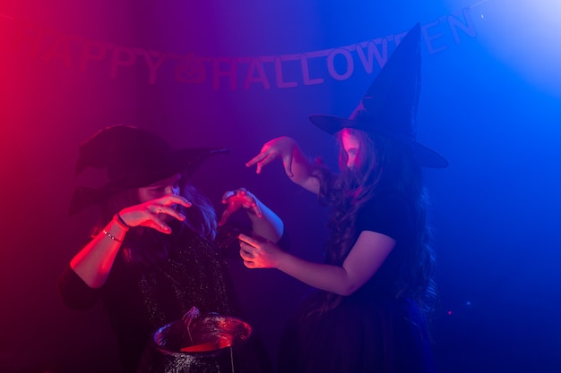 Zdjęcie dwie halloweenowe czarownice robiące magię w halloweenowych nocnych magicznych świętach i mistycznej koncepcji