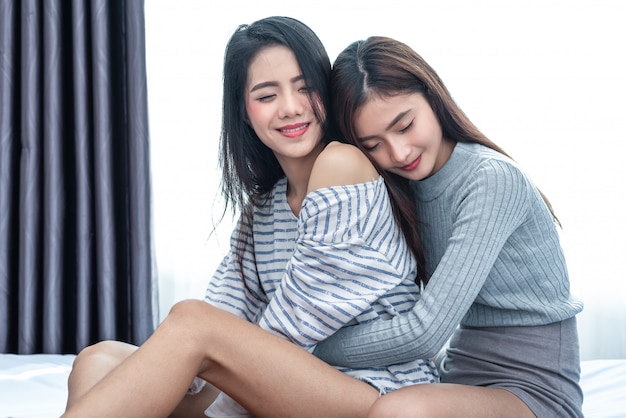 Dwie kobiety azjatyckich lesbijek przytulić i obejmując razem w sypialni.