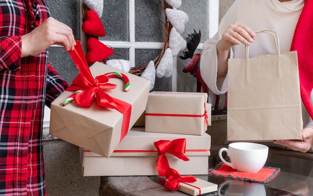 Dwie kobiety pakują prezenty w przeddzień świąt Bożego Narodzenia i Nowego Roku.