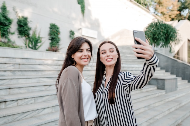 Dwie kobiety robi selfie na zewnątrz w mieście