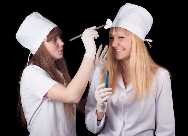 dwie kobiety w białych kapeluszach jedna w białym kapeluszu, a druga z nożem w ręku