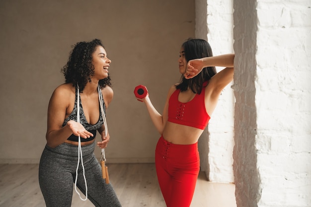 Dwie kobiety zadowolone z pobytu w klubie fitness, dając sobie po pięć