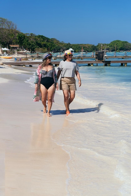 Dwie koleżanki spacerują razem po plaży latem