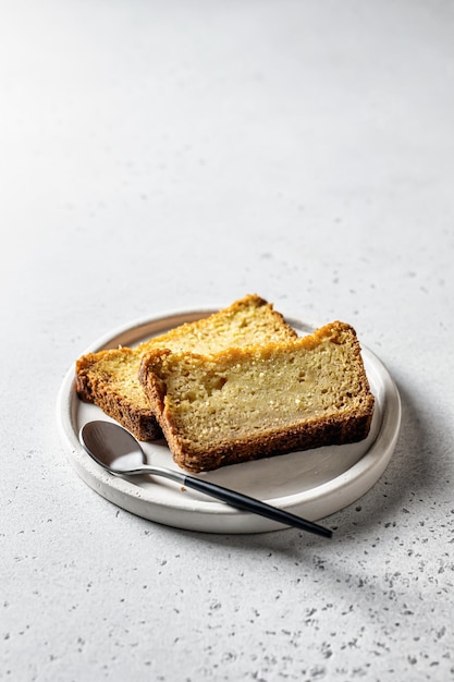 Dwie kromki chleba dyniowego na białym talerzu na szarym tle Jesienny deser z miejscem na tekst