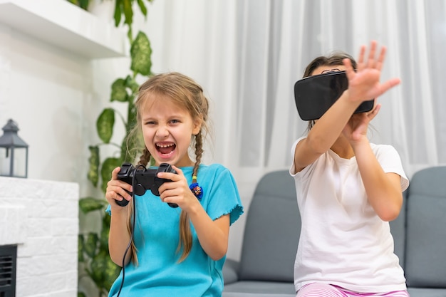 Dwie Małe Dziewczynki Za Pomocą Okularów Wirtualnej Rzeczywistości Zestawu Słuchawkowego. Koncepcja Nowoczesnych Technologii