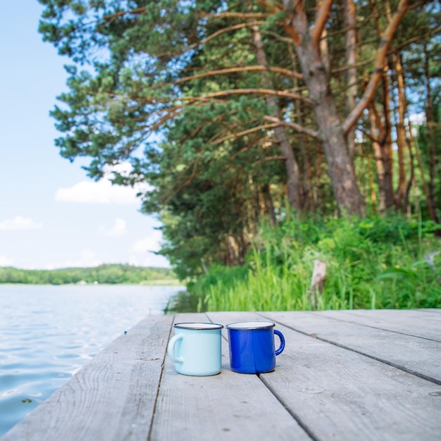 Zdjęcie dwie metalowe kubki z rzeką herbaty na tle koncepcji czasu letniego