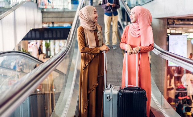 Dwie Młode Azjatyckie Kobiety Muzułmańskie, Ciesząc Się Czasem Na Zakupy, Letnią Wyprzedażą, Spacer I Zabawę, Rozmawiając Ze Sobą, Aby Kupić Coś W Sklepie W Sklepie Z Modą