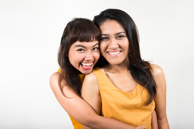 dwie młode azjatyckie kobiety razem przeciwko białej przestrzeni