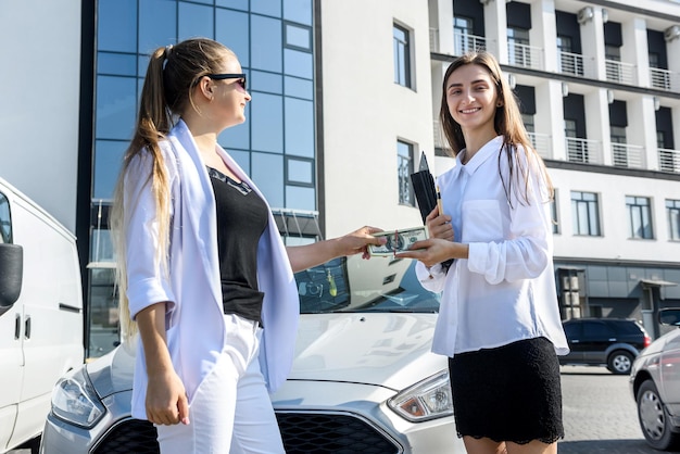 Dwie młode biznesowe panie negocjują w pobliżu centrum biznesowego